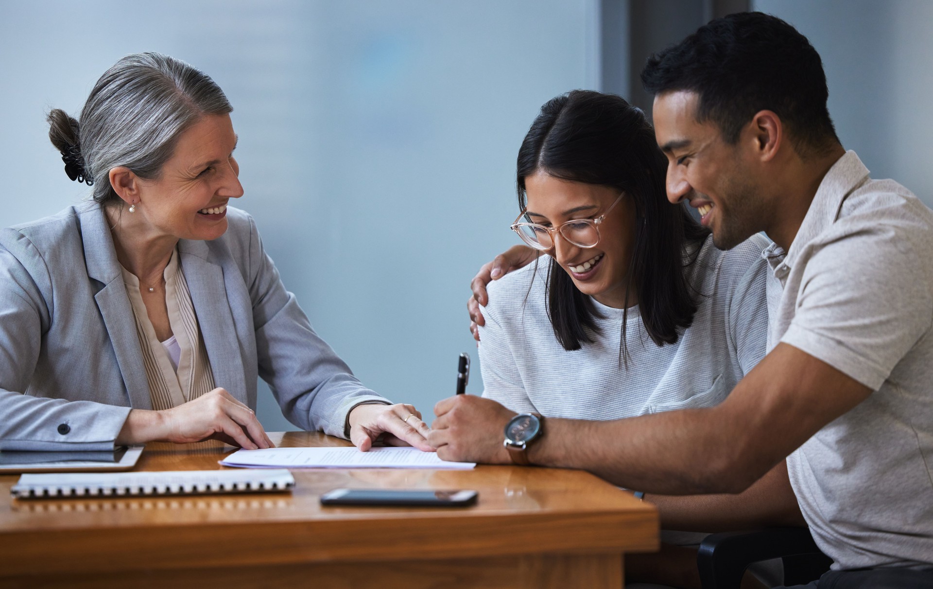 Shot of a young couple meeting with a consultant to discuss paperwork an office