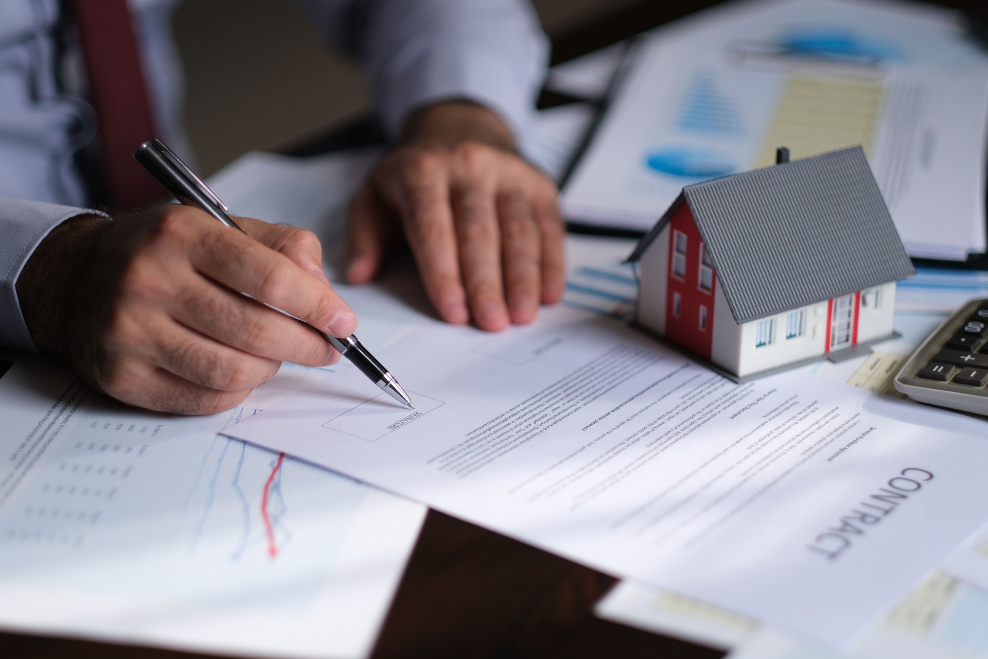 Businessman signing a mortgage contract of a sale for a new house